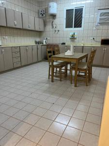 a kitchen with a table and chairs and a tiled floor at شقة بغرفة نوم وصالة in Unayzah