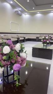 Zimmer mit lila und weißen Blumen auf dem Tisch in der Unterkunft شالية المزرعة 