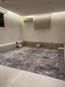 Zimmer mit Sofas und einem Teppich auf dem Boden in der Unterkunft شقة بغرفة نوم وصالة in Unaizah