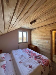 a bed in a room with a wooden ceiling at La Văru in Cîrţişoara
