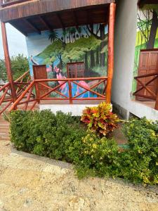 un murale sul lato di un edificio con fiori di hotel palmares beach a Palomino