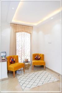 Duas cadeiras cor-de-laranja numa sala de estar com uma janela em Fabuleuse Villa Marrakchi em Marrakech
