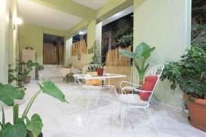 patio ze stołem, krzesłami i roślinami w obiekcie The Green House With Υard w Pireusie