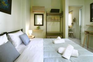 sypialnia z dużym białym łóżkiem z 2 poduszkami w obiekcie The Green House With Υard w Pireusie
