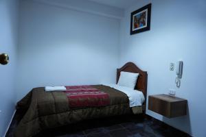 Schlafzimmer mit einem Bett mit blauer Wand in der Unterkunft Hotel San Martin - Cajamarca in Cajamarca