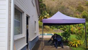 a purple umbrella on a porch next to a pool at VILLA -Le Chalet Tropical in Le Marin