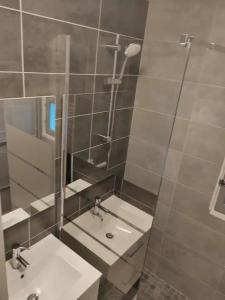 a bathroom with two sinks and a shower with a mirror at Une Chambre dans Appartement - Grenoble, France à 8 min du centre-ville in Grenoble