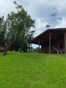 un edificio con una hamaca en un campo de césped en Refúgio no Caraá, en Caraá