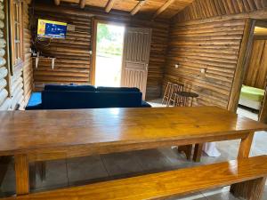 una gran mesa de madera en una habitación con sofá en Refúgio no Caraá, en Caraá