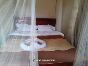 Kalangala的住宿－Pelican Resort Beach，一间卧室配有两张带白色床单的床