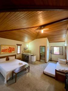 a bedroom with two beds and a wooden ceiling at Pousada Lua Cheia in Búzios