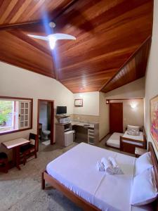 1 dormitorio con 1 cama grande y techo de madera en Pousada Lua Cheia, en Búzios