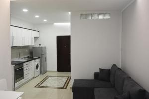 a living room with a couch and a kitchen at Sea Apartment Golem in Golem