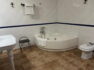 a bathroom with a tub and a toilet and a sink at Hotel A Posada in Tembleque +21 photos