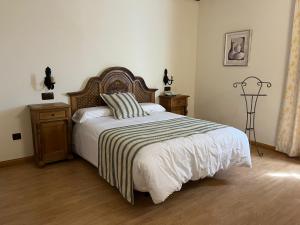 1 dormitorio con 1 cama grande con manta a rayas en Hotel A Posada en Tembleque