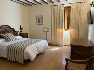 1 dormitorio con cama, escritorio y ventana en Hotel A Posada en Tembleque