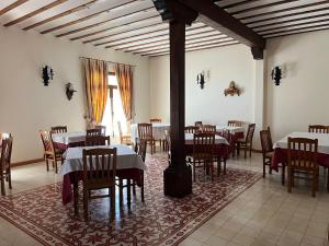uma sala de jantar com mesas e cadeiras e uma lareira em Hotel A Posada em Tembleque