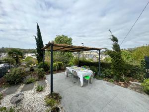 eine Terrasse mit einem Tisch und einem Pavillon in der Unterkunft Le Repos des Rias, maison au cœur de la ville in Quimperlé