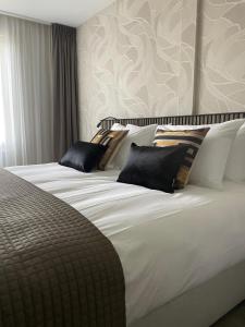 Un dormitorio con una cama grande con almohadas. en Boutique Hotel Hans, en Badhoevedorp