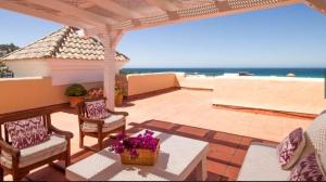 a patio with a table and chairs and the ocean at Las Casas de Mar Atlanterra in Zahara de los Atunes