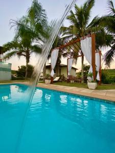 a fountain in a pool with palm trees in the background at Pousada Lua Cheia in Búzios