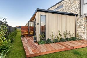 a house with a wooden deck in the yard at The Front Room in Wanaka