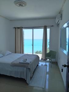 1 dormitorio con cama y vistas al océano en Hotel Alto Velo Beach, en Bejuquero