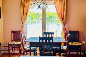 ein Esszimmer mit einem Tisch, Stühlen und einem Fenster in der Unterkunft Evergreen Cottage in Norway