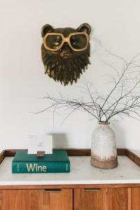 a table with a book and a vase with glasses at Woodland Chase - Pool & Hot Tub by Wineries ST 2020-0259 in Wellington