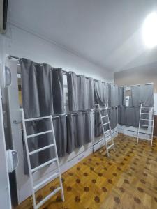 een kamer met grijze gordijnen en twee ladders bij K A N G A R L I Hostel & Hotel in Baku
