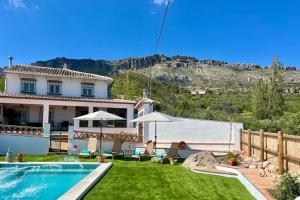 a villa with a swimming pool and a house at Casa Rubito el Olmo in Villanueva de la Concepción