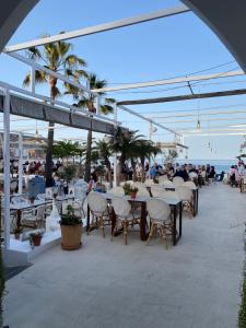 a group of tables and chairs on the beach at Saona Coast - Apartamento reformado en playa Arenal, Jávea in Jávea