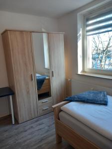 sypialnia z szafką, łóżkiem i oknem w obiekcie City Apartment Duisburg 2#Netflix &Wlan &Kingsize Bett &Central w mieście Duisburg