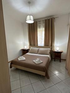 una camera da letto con un letto e due asciugamani di Casa Nereide a Giardini Naxos