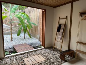 a room with a glass door with a plant outside at Habitación luxury Loto Mendihuaca tayrona in Santa Marta