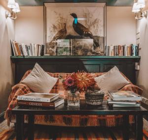 a living room with a couch with books and a table at The Hare & Hounds Inn in Bowland Bridge