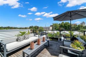 a patio with a couch and an umbrella at NEW! The Humidor - 2 Epic, Luxury Ybor Townhomes, Steps to 7th Ave in Tampa