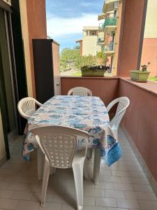 un tavolo e sedie su un balcone con tavolo e finestra di Casa Nereide a Giardini Naxos