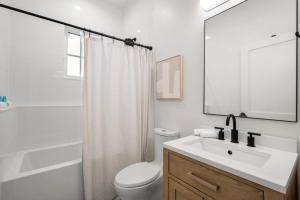 a white bathroom with a toilet and a sink at NEW! The Humidor - 2 Epic, Luxury Ybor Townhomes, Steps to 7th Ave in Tampa