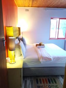 1 dormitorio con 1 cama y 1 lámpara en una mesa en Neo & Ruks Guest house Parow, en Ciudad del Cabo