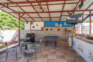 d'une terrasse avec une table, des chaises et une télévision. dans l'établissement Casa, 3 dormitorios, piscina, rancho, cocina, minibar, pingpong, 9 personas, à Capulín