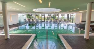 a swimming pool with a glass floor in a building at Wellnesshotel Hohenrodt in Loßburg +158 photos