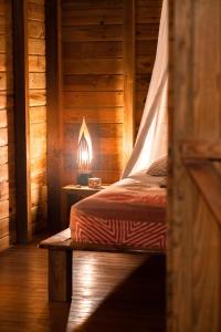 1 dormitorio con 1 cama con lámpara en una mesa en Au Jardin Des Colibris Ecolodge&Spa en Deshaies