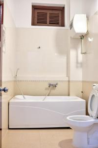 biała łazienka z wanną i toaletą w obiekcie Kim's Homestay & Villa w Ha Long