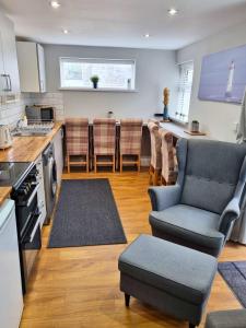 cocina y sala de estar con sofá y sillas en Portrush by the Sea - 4 Princess Green, en Portrush