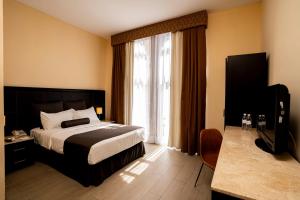 Cette chambre comprend un lit et une grande fenêtre. dans l'établissement Hotel San Francisco, à San Luis Potosí
