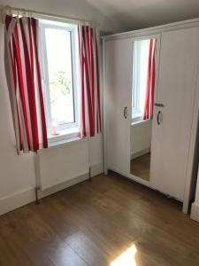 an empty room with two windows and a mirror at Spacious 3 bed townhouse in Dublin 12 in Dublin