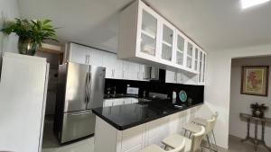 a kitchen with white cabinets and a stainless steel refrigerator at APARTAMENTO BOCA DEL MAR EN BOCA CHICA in Cuevas
