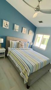 a bedroom with a bed with a blue wall at Easy Ocean Access 30' Dock - House - Private Club w/ Heated Pool and Sandy Beach in Key Colony Beach