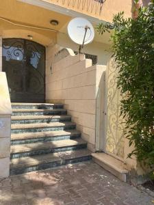 a set of stairs leading to a door with a gate at Family house in Ma‘ān